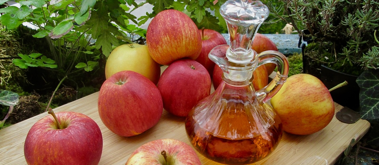 Apples on a cutting board with apple cider vinegar.