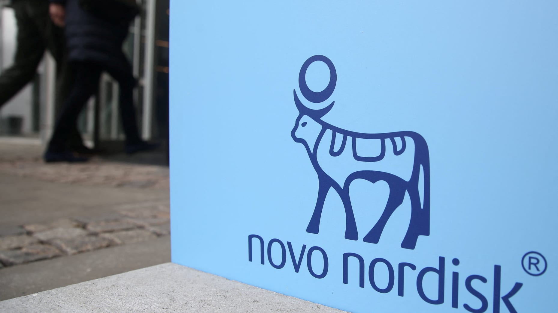 People walk past a sign for Novo Nordisk’s annual general meeting at the entrance to the venue in Copenhagen, Denmark,  March 26, 2026. REUTERS/Tom Little